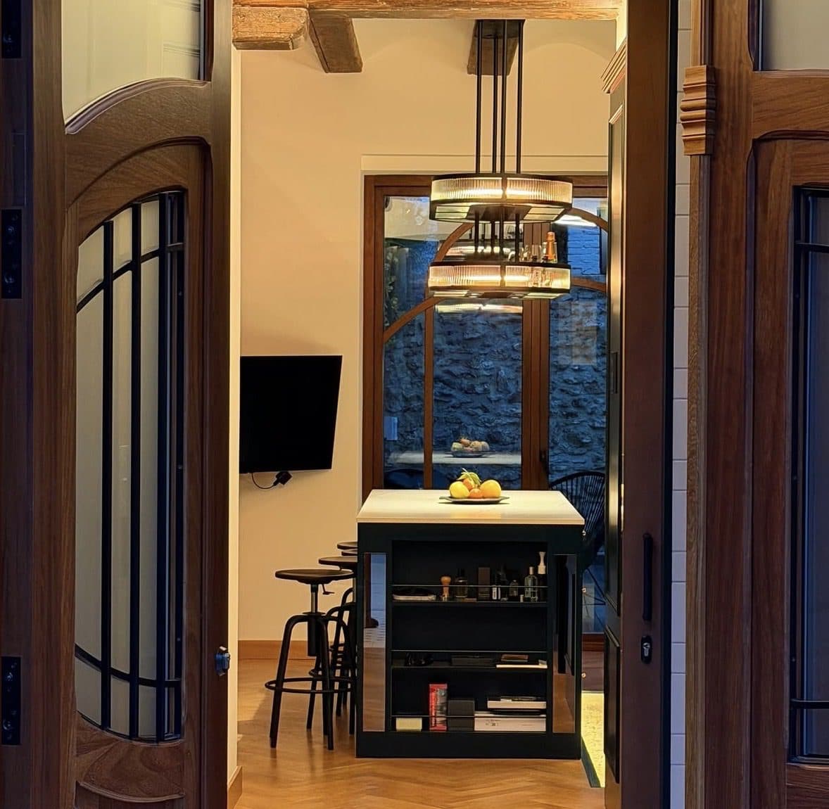 Puertas de paso de madera con vidrio y celosía, abiertas hacia una cocina